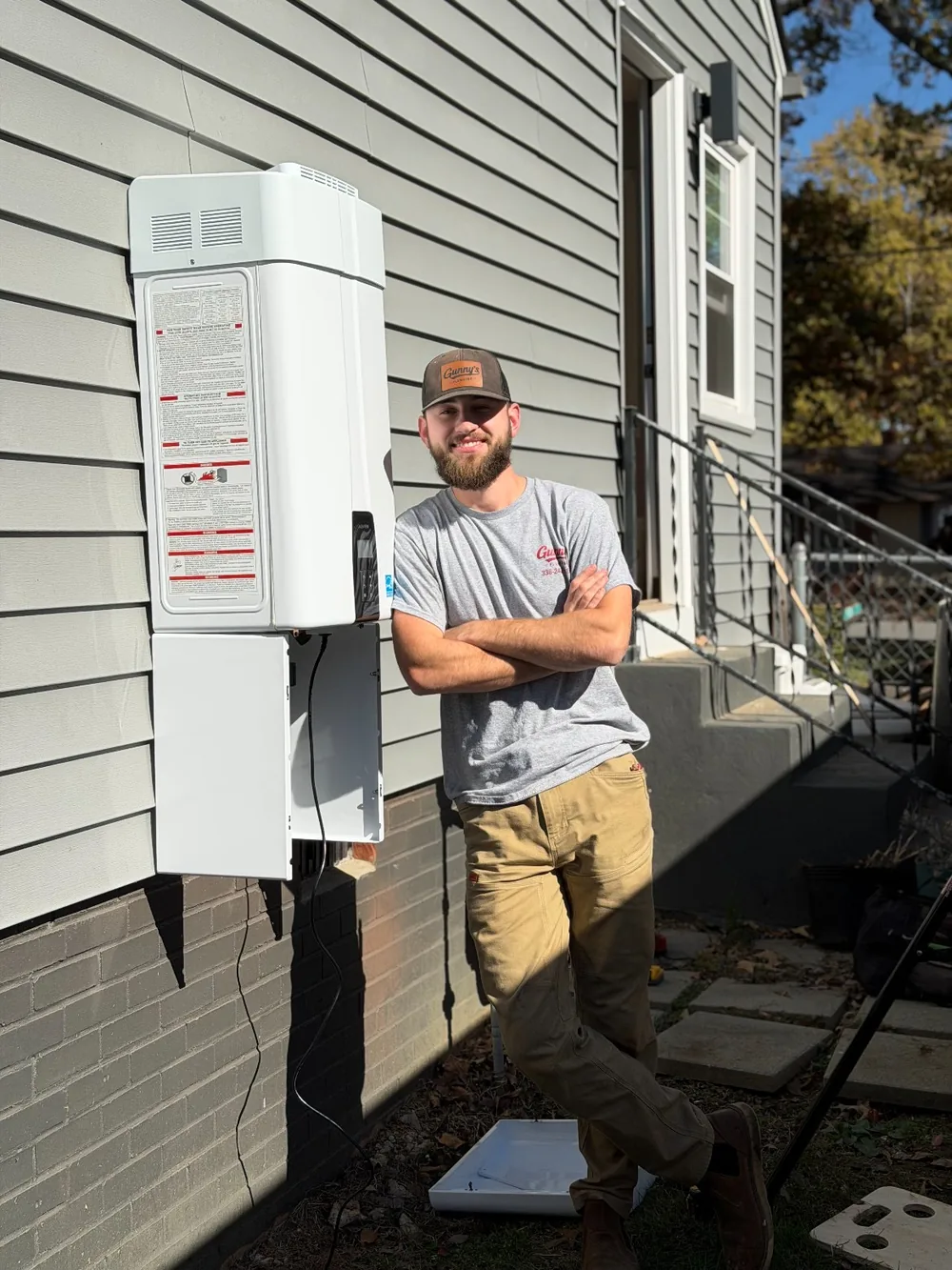 Caleb Gundaker of Gunny's Plumbing beside a newly installed tankless water heater