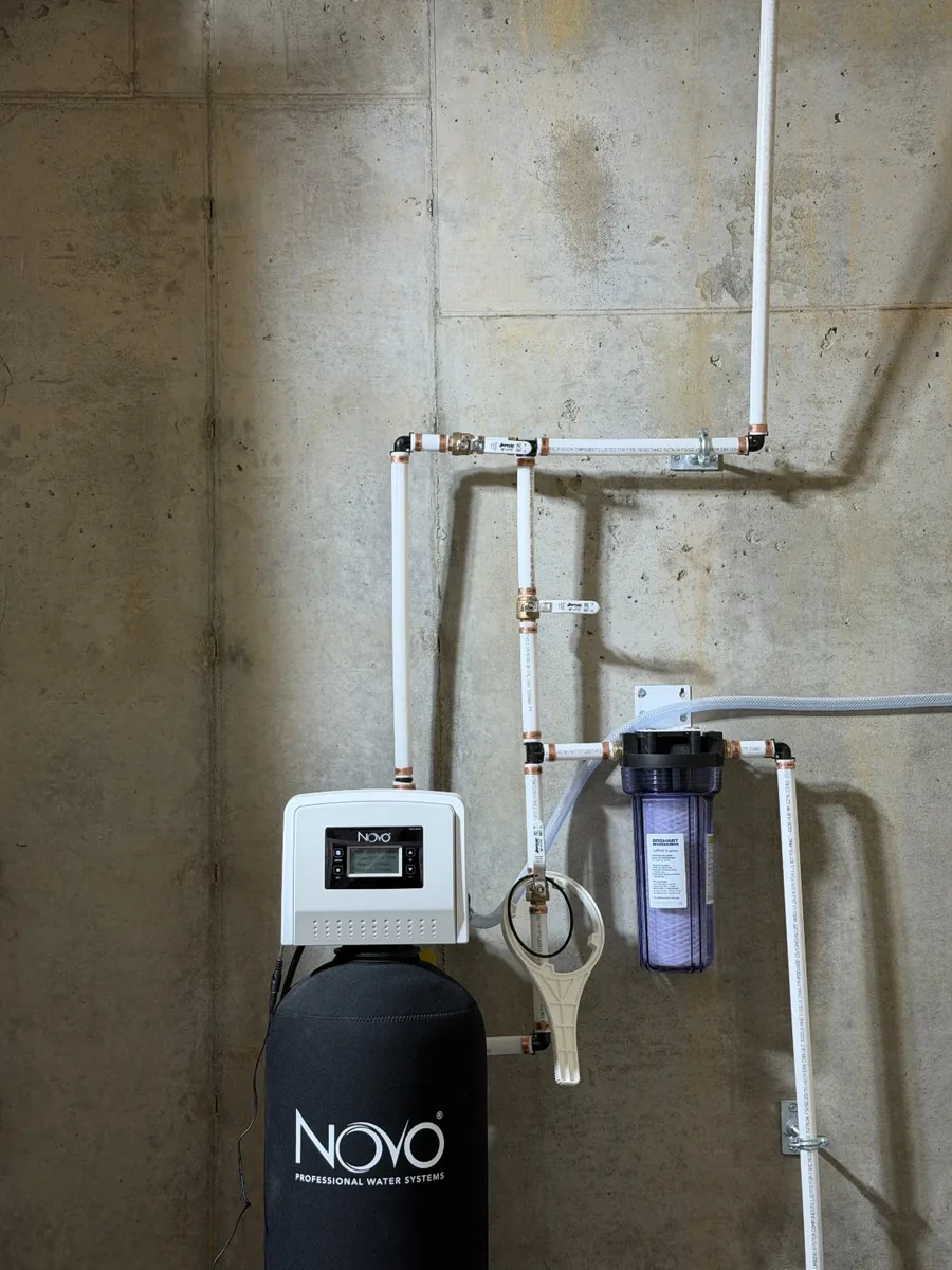 Whole-house softener and sediment filter plumbed on a block wall